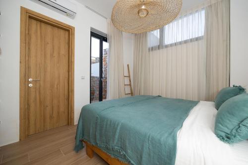 a bedroom with a bed and a large window at The Nine Graces - Kastraki Villas with Private Swimming Pool in Kastraki Naxou