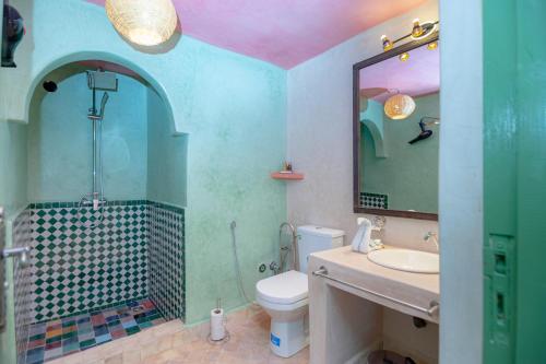a bathroom with a sink and a toilet and a mirror at Smile House Imlil in Imlil