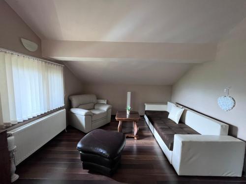 een woonkamer met een bank en een stoel bij Къща за гости Милена in Apriltsi