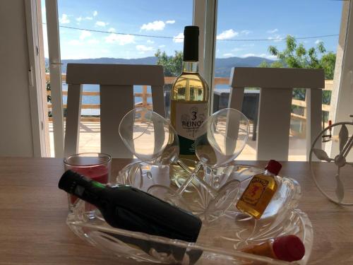 Una botella de vino y dos copas en una mesa. en CASA MAR DE LUNA Playas en Raxo, en Raxó