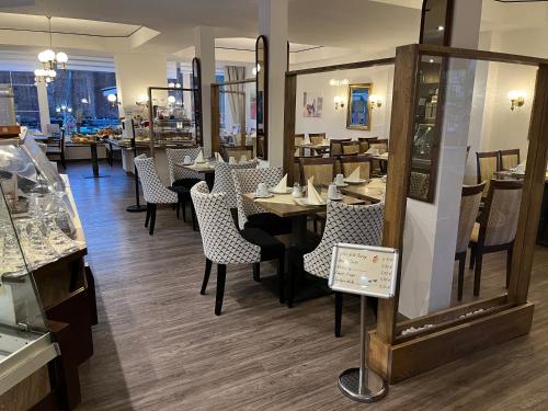 a dining room with tables and chairs in a restaurant at Hotel Rosengarten in Bad Salzuflen