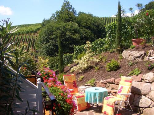a garden with a table and chairs and flowers at Landhaus Schneider in Sasbachwalden