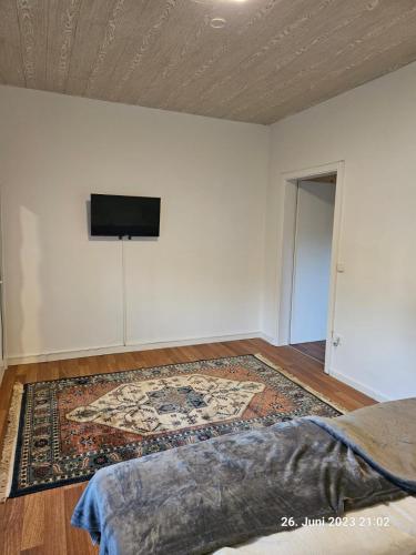 a room with a tv on the wall and a rug at Komfortable 3-Zimmer-Wohnung in Neubeckum in Beckum