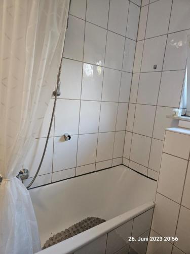 a bathroom with a tub with a shower curtain at Komfortable 3-Zimmer-Wohnung in Neubeckum in Beckum