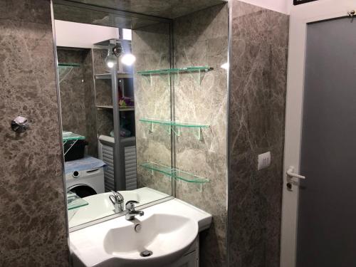 een badkamer met een wastafel en een douche met een spiegel bij Lili's House in Delvinë