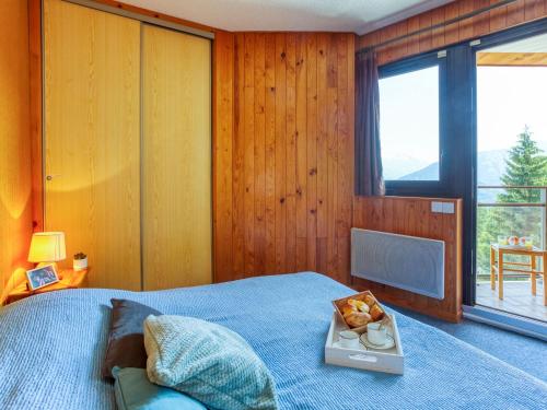 a bedroom with a bed with a tray of food on it at Apartment Ariane-3 by Interhome in Le Corbier