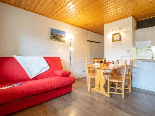 sala de estar con sofá rojo y mesa en Apartment Les Asters-15 by Interhome, en Les Menuires