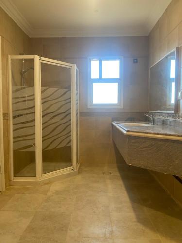 La salle de bains est pourvue d'une douche en verre et d'un lavabo. dans l'établissement ليالي الخالدية, à Riyad