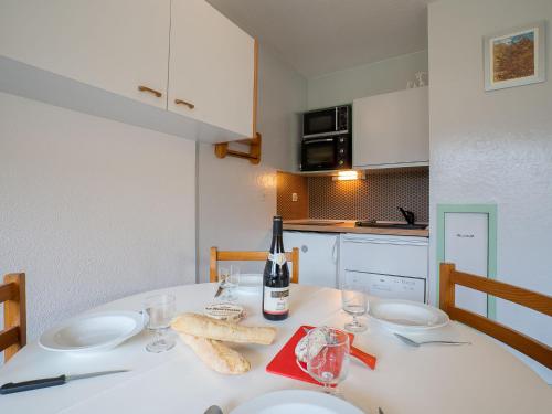 a white table with a bottle of wine and glasses at Apartment Asters 722 Bâtiment B2 by Interhome in Les Menuires