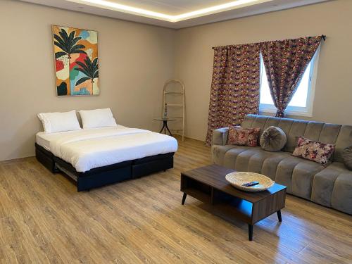 - un salon avec un lit et un canapé dans l'établissement ليالي الخالدية, à Riyad