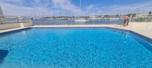 une grande piscine bleue avec vue sur le port de plaisance dans l'établissement Appartement avec balcon, vue Mer, Piscine, Parking, au Cap d'Agde