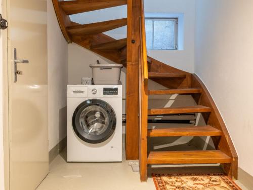 a laundry room with a staircase next to a washing machine at Holiday Home Sonnenbühl by Interhome in Dittishausen