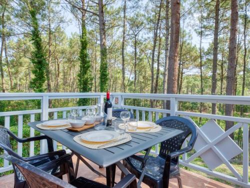 - une table avec des chaises et une bouteille de vin sur la terrasse dans l'établissement Apartment Domaine Golf Resort-1 by Interhome, à Lacanau-Océan