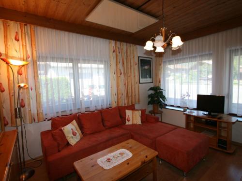 a living room with a red couch and a table at Apartment Peter by Interhome in Waidring