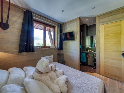 a teddy bear sitting on a bed in a bedroom at Apartment Apollo-4 by Interhome in Le Corbier