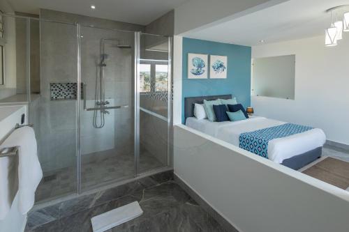 a bedroom with a king sized bed and a shower at O'Beach Boutique Studios in Flic-en-Flac