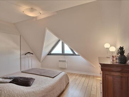 - une chambre mansardée avec un lit et une grande fenêtre dans l'établissement Apartment Belle Vue Mer et Groix by Interhome, à Ploemeur