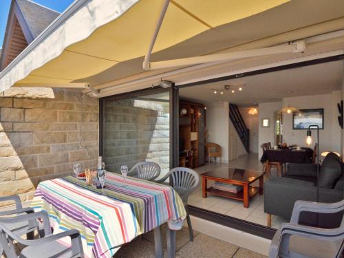 a patio with a table and chairs and a piano at Apartment Belle Vue Mer et Groix by Interhome in Ploemeur