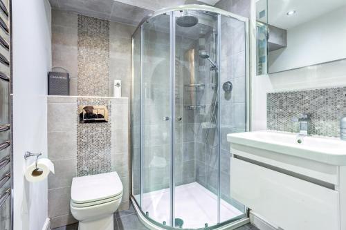 uma casa de banho com um chuveiro, um WC e um lavatório. em Woodside Cottage, Congleton, Nr Peak District em Congleton