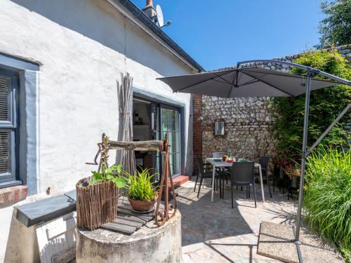 eine Terrasse mit einem Sonnenschirm und einem Tisch in der Unterkunft Holiday Home Entre mer et jardin - PPT401 by Interhome in Saint-Pierre-en-Port