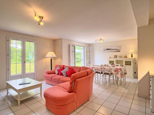 a living room with a red couch and a table at Holiday Home Ar Mimoza - LBO301 by Interhome in Le Bono