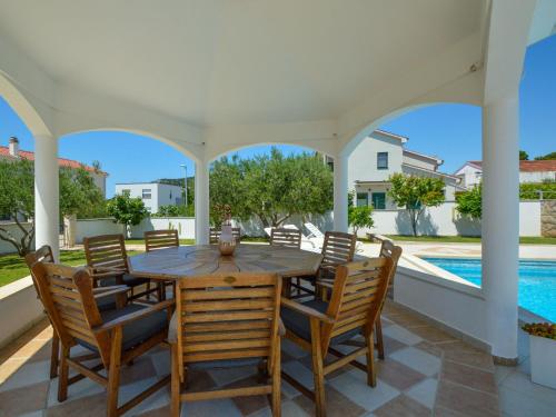 a patio with a table and chairs and a swimming pool at Apartment Aquanur-5 by Interhome in Sovlje