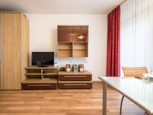 a living room with a television and a table at Apartment B212 by Interhome in Lahnstein