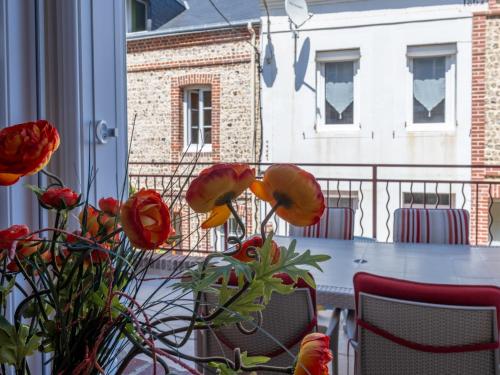a table and chairs with flowers on a balcony at Holiday Home La Rose des Vents - YPO401 by Interhome in Yport
