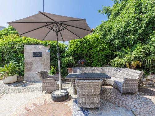 een patio met een tafel en stoelen met een parasol bij Apartment Romantika-2 by Interhome in Rovinj