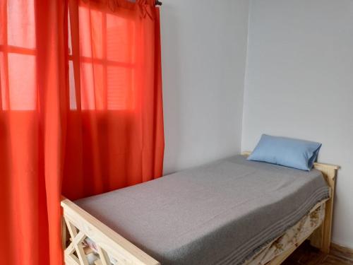 a bed in a room with red curtains at La Casona-Departamentos in Mar del Plata