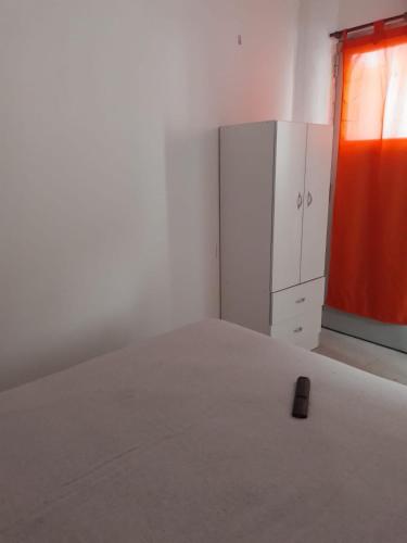 an empty room with a white room with an orange door at La Casona-Departamentos in Mar del Plata