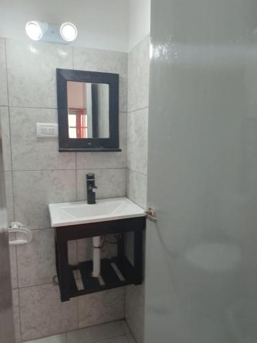 a bathroom with a sink and a mirror at La Casona-Departamentos in Mar del Plata