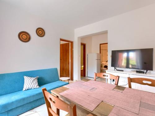 een woonkamer met een blauwe bank en een tafel bij Apartment Romantika-3 by Interhome in Rovinj