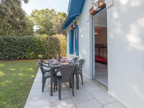 een tafel en stoelen op de patio van een huis bij Holiday Home Domremy by Interhome in Saint-Palais-sur-Mer