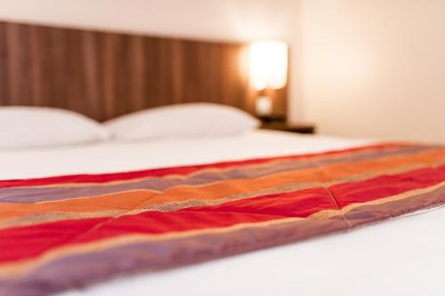 a close up of a bed in a hotel room at Hotel Eurocentre 2* Toulouse Nord in Castelnau-dʼEstrétefonds