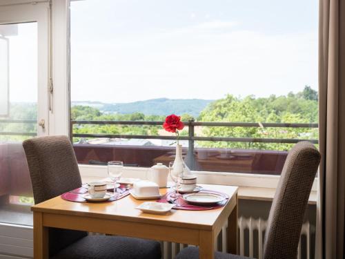 a table with a vase with a red flower on it at Apartment B712 by Interhome in Lahnstein