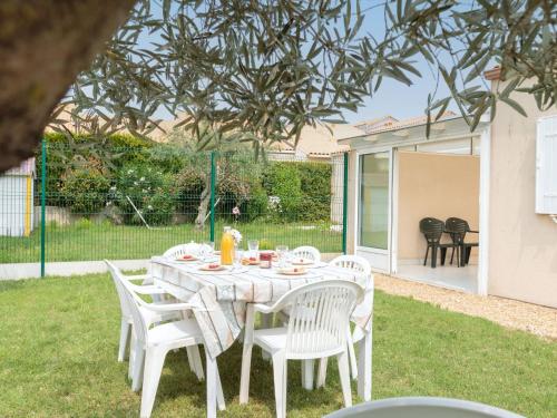 een witte tafel en stoelen in een tuin bij Holiday Home Brive 2 by Interhome in Pontaillac