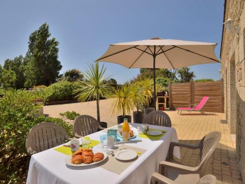 une table avec une assiette de nourriture et un parapluie dans l'établissement Holiday Home Houat-Hoedic-Belle-Ile by Interhome, à Plouhinec