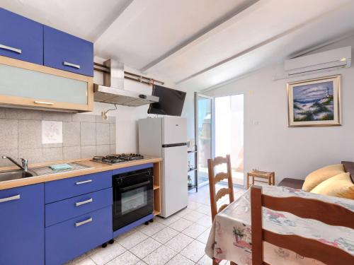 a kitchen with blue cabinets and a stove top oven at Apartment Romantika - ROJ105 by Interhome in Rovinj
