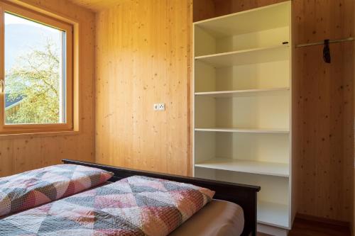 - une chambre avec un lit, une fenêtre et des étagères dans l'établissement Bergreich Appartement 3, à Schoppernau