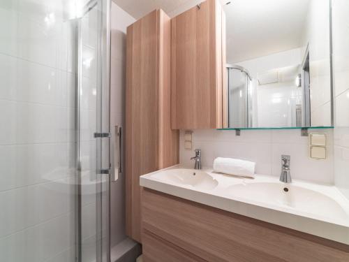 łazienka z 2 umywalkami i prysznicem w obiekcie Apartment Les Marines-41 by Interhome w mieście La Foux