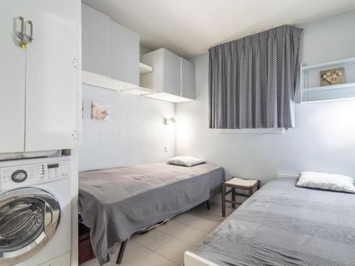 Apartment Les Marines-41 by Interhome في La Foux: غرفة بسريرين وغسالة ملابس