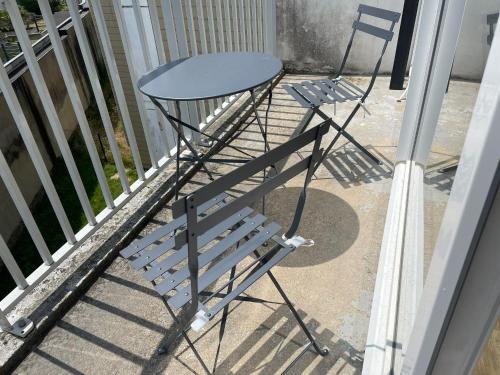 two chairs and a table on a balcony at Studio Rouen in Rouen