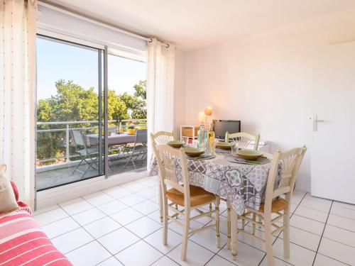 une salle à manger avec une table et des chaises et un balcon dans l'établissement Apartment Zéphyr-1 by Interhome, à Arcachon
