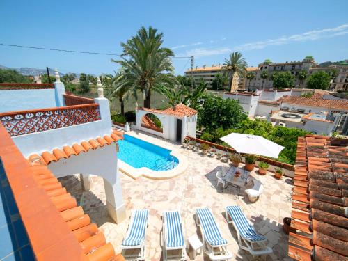 a villa with a swimming pool and lounge chairs at Holiday Home Alan by Interhome in Albir