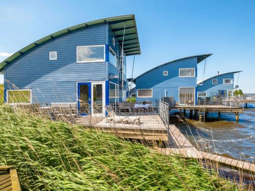 a house on the water with a dock at Holiday Home Rietwoning 16 by Interhome in Anjum