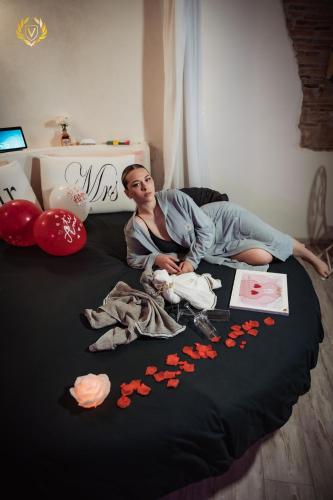 a man laying on a bed with flowers on it at VenuSuite VENOSA - Luxury House, Spa & Relax - in Venosa