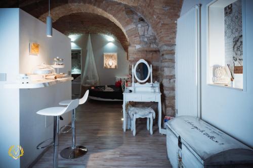 a room with a bed and a vanity with a mirror at VenuSuite VENOSA - Luxury House, Spa & Relax - in Venosa