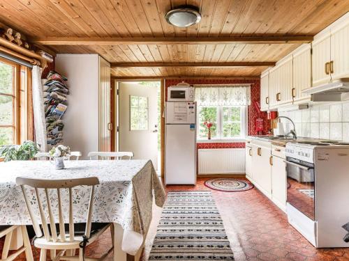 a kitchen with a table and a refrigerator at Holiday Home Röshult by Interhome in Kyrkhult