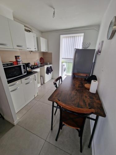 Il comprend une cuisine avec une table et des chaises en bois. dans l'établissement Appparement T3 Marseille 13009, à Marseille